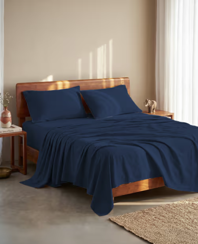 Navy blue bed linen set on a wooden bed frame